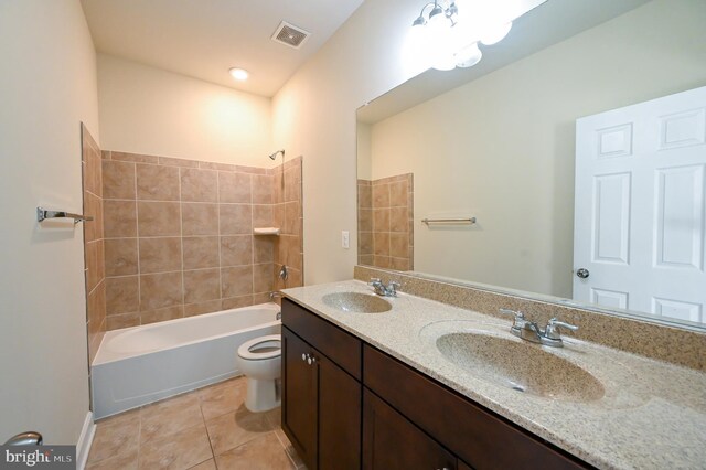 full bathroom with tiled shower / bath, toilet, tile patterned flooring, and vanity