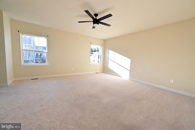 unfurnished room with ceiling fan, plenty of natural light, and baseboards