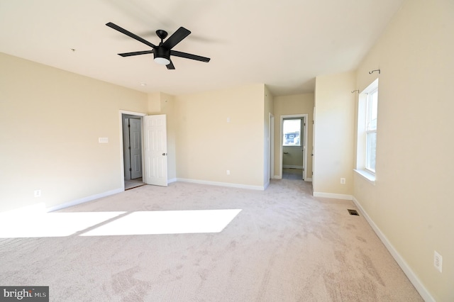 unfurnished bedroom featuring a ceiling fan, light colored carpet, visible vents, and baseboards