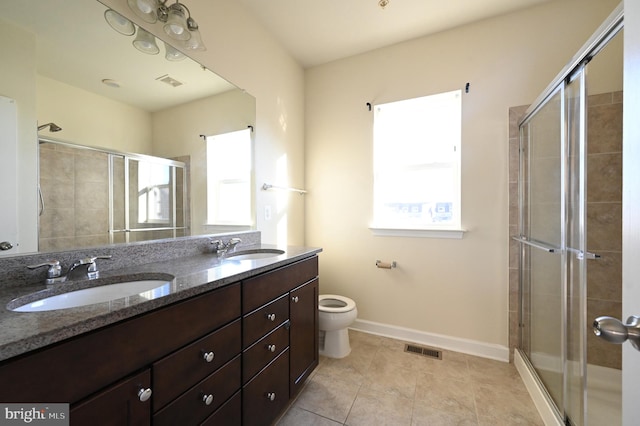 bathroom featuring tile patterned flooring, toilet, vanity, and walk in shower