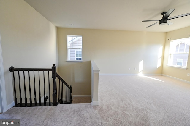 stairs featuring ceiling fan and carpet flooring