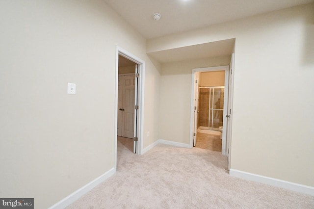 corridor with light carpet and baseboards