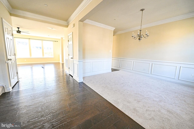 spare room featuring dark hardwood / wood-style flooring, ceiling fan with notable chandelier, and ornamental molding