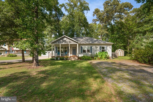 view of front of property featuring a storage unit, a porch, and a front lawn