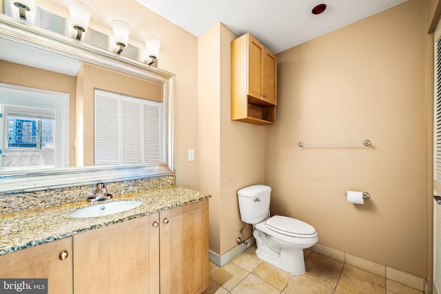 bathroom featuring a closet, baseboards, vanity, and toilet