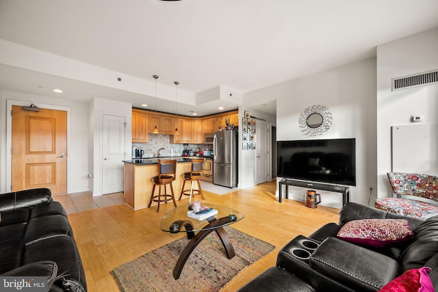 living area featuring light wood-style floors, visible vents, and recessed lighting