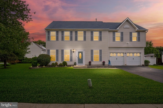 colonial house with a garage and a lawn