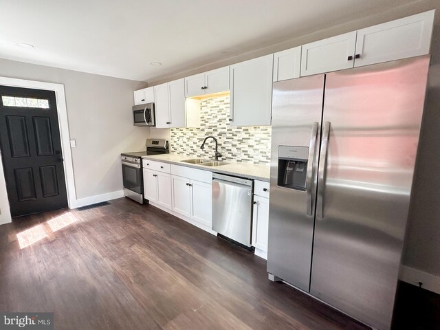 kitchen featuring dark hardwood / wood-style flooring, white cabinets, sink, and appliances with stainless steel finishes