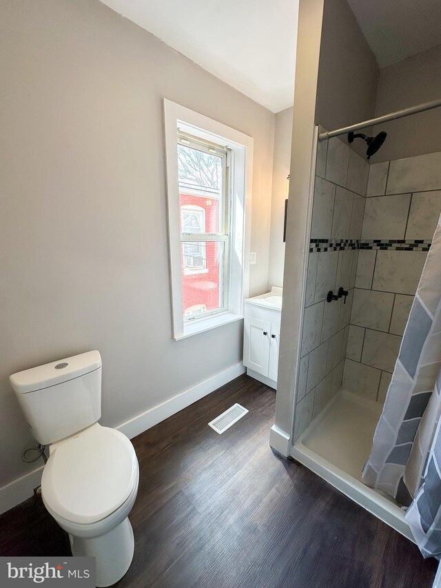 bathroom featuring curtained shower, toilet, vanity, and wood-type flooring