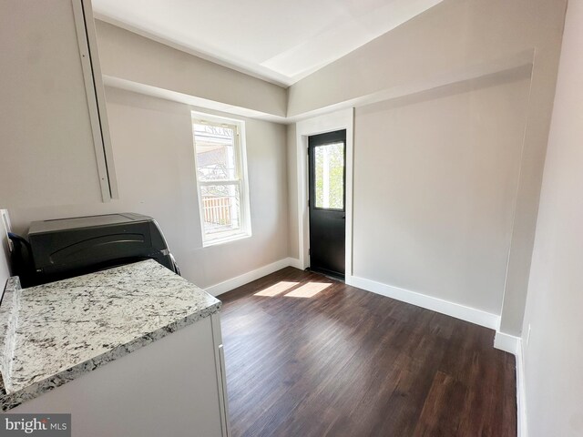 interior space featuring hardwood / wood-style floors, washer / dryer, and light stone countertops