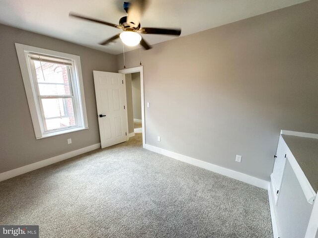 empty room with ceiling fan and light colored carpet