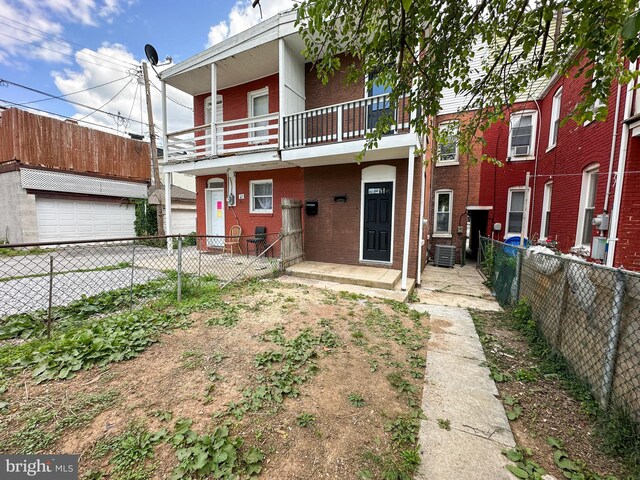 back of house featuring a balcony, central air condition unit, and a garage