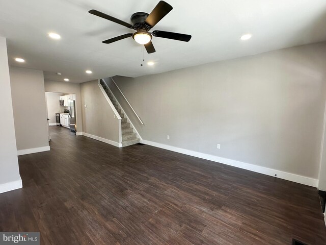 empty room with ceiling fan and dark hardwood / wood-style flooring