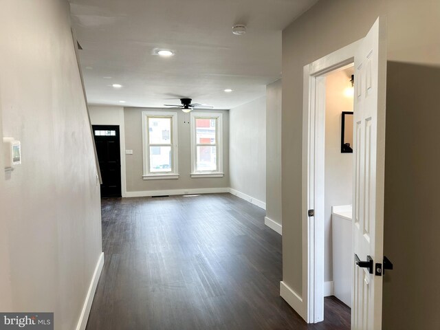 empty room with ceiling fan and dark wood-type flooring