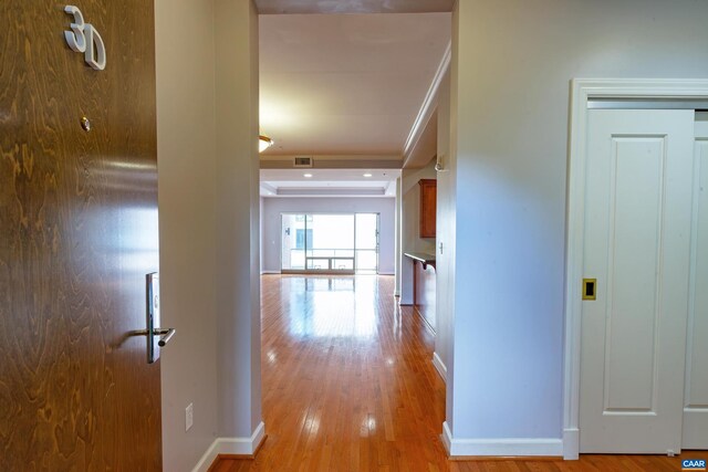 kitchen with sink, light hardwood / wood-style floors, crown molding, and stainless steel refrigerator