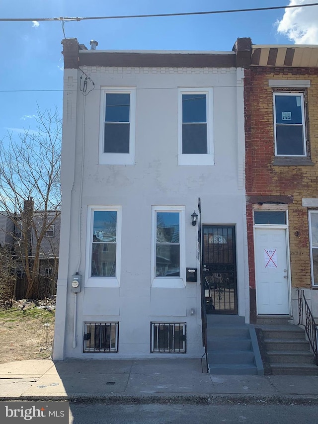 townhome / multi-family property with entry steps and stucco siding