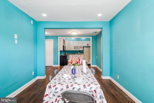 bedroom with white fridge and dark hardwood / wood-style floors