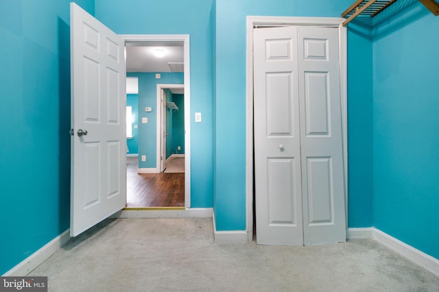 unfurnished bedroom with a closet and light carpet