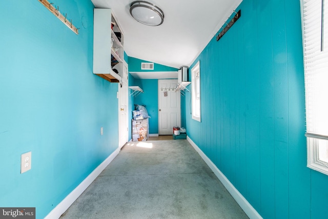 corridor with carpet, plenty of natural light, and vaulted ceiling