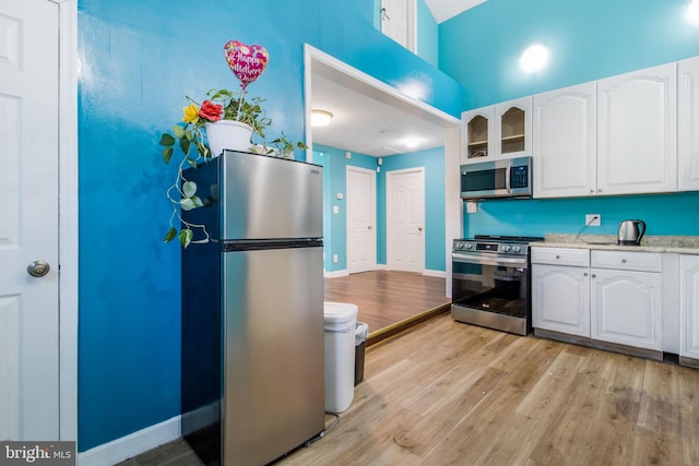 kitchen featuring white cabinetry, stainless steel appliances, and light wood-type flooring