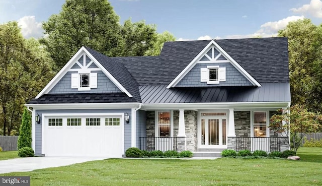 view of front facade with covered porch, stone siding, a front lawn, and a standing seam roof