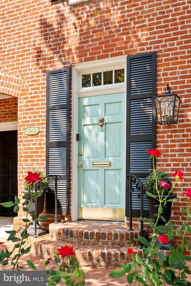 view of exterior entry with brick siding