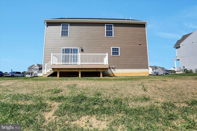 rear view of property featuring a wooden deck and a yard