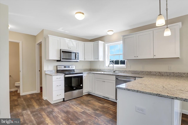 kitchen featuring appliances with stainless steel finishes, pendant lighting, dark hardwood / wood-style flooring, and white cabinetry