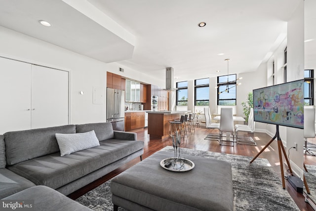 living room with sink, hardwood / wood-style floors, and a notable chandelier