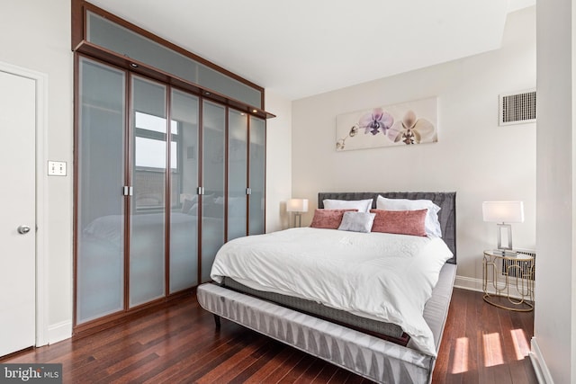 bedroom with dark wood-type flooring