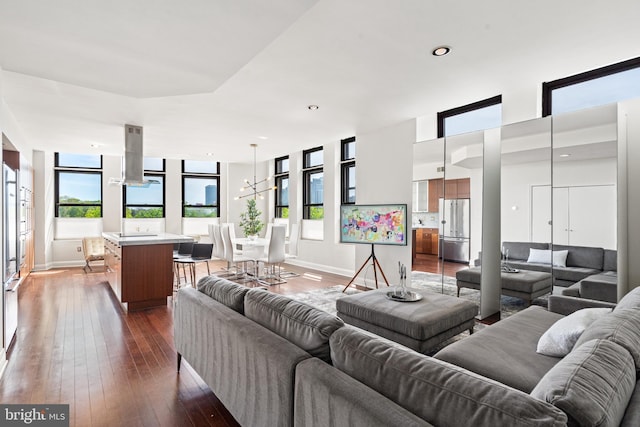 living room with an inviting chandelier and dark hardwood / wood-style flooring