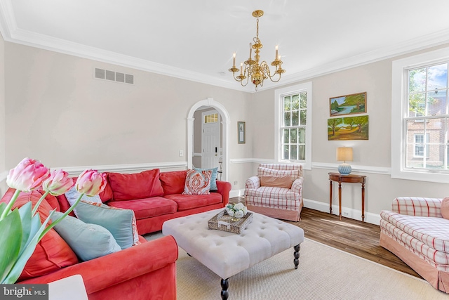 living room featuring a chandelier, hardwood / wood-style floors, and crown molding