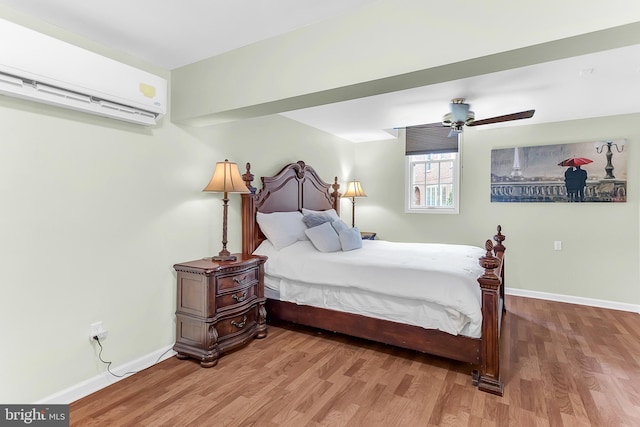 bedroom with ceiling fan, hardwood / wood-style floors, and a wall mounted AC