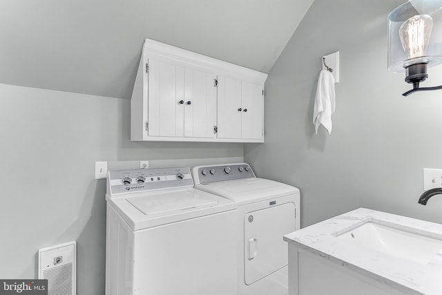 laundry area with sink, washer and dryer, and cabinets