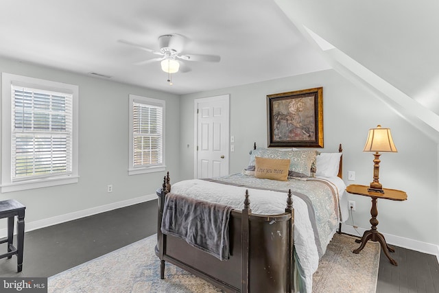 bedroom featuring multiple windows, dark hardwood / wood-style floors, and ceiling fan