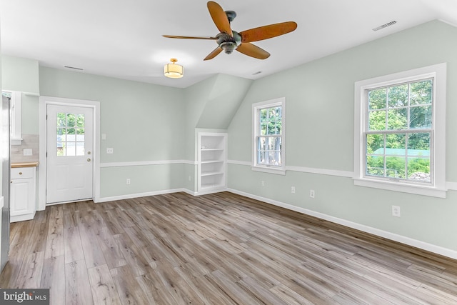 interior space with ceiling fan, light wood-type flooring, plenty of natural light, and lofted ceiling