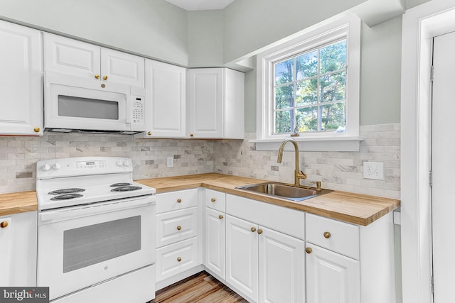 kitchen with white appliances, wooden counters, and white cabinets