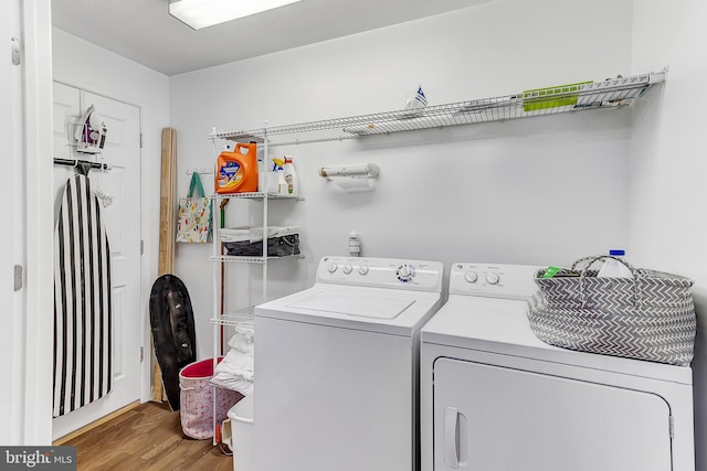 washroom with hardwood / wood-style floors and washing machine and dryer