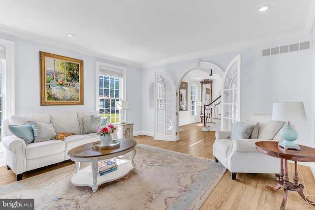 living room featuring light hardwood / wood-style flooring and crown molding