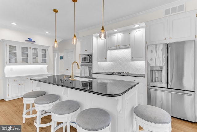 kitchen with white cabinets, appliances with stainless steel finishes, and light wood-type flooring