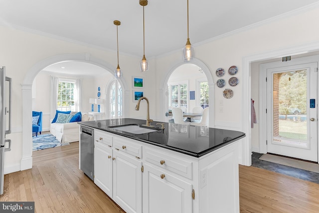 kitchen featuring pendant lighting, sink, white cabinetry, appliances with stainless steel finishes, and light wood-type flooring