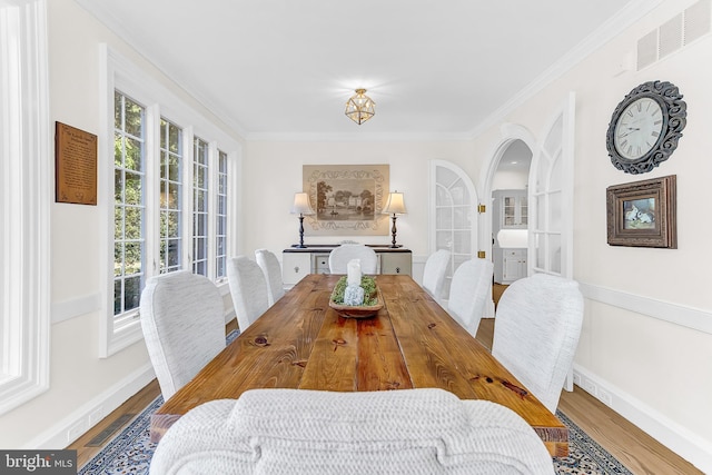 dining room with hardwood / wood-style flooring and ornamental molding