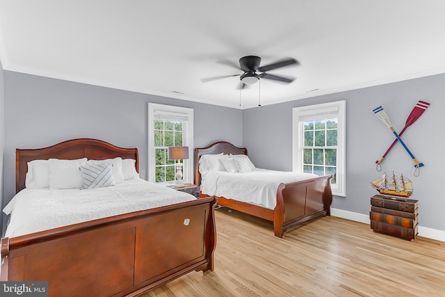 bedroom featuring crown molding, ceiling fan, and light hardwood / wood-style flooring