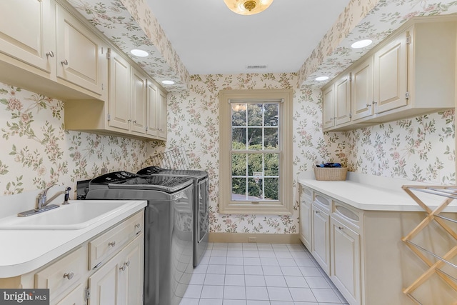 laundry room featuring light tile patterned floors, sink, independent washer and dryer, and cabinets