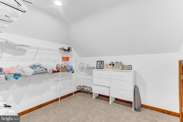 carpeted bedroom with lofted ceiling and a wall mounted air conditioner