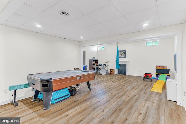 rec room featuring light wood-type flooring and a paneled ceiling