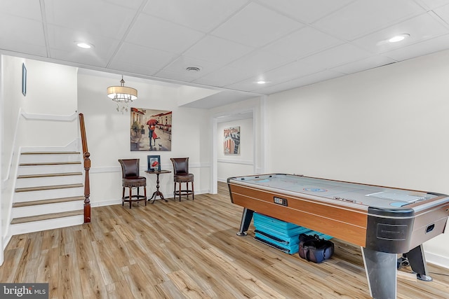 playroom featuring a paneled ceiling and hardwood / wood-style flooring