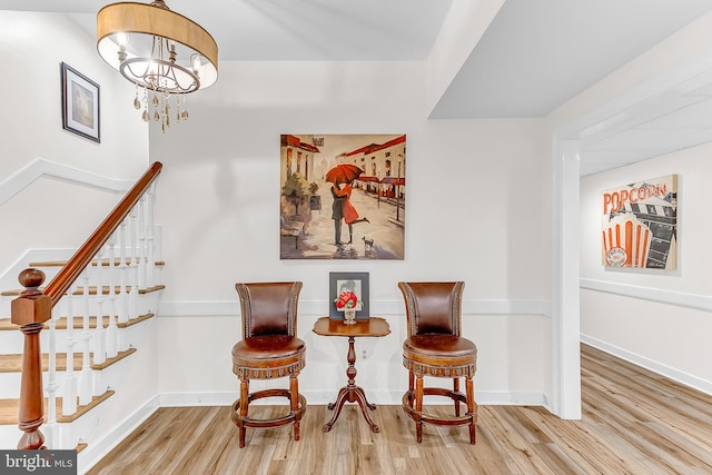 sitting room with an inviting chandelier and hardwood / wood-style floors