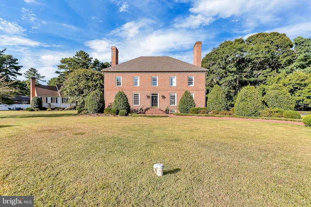 colonial home featuring a front lawn