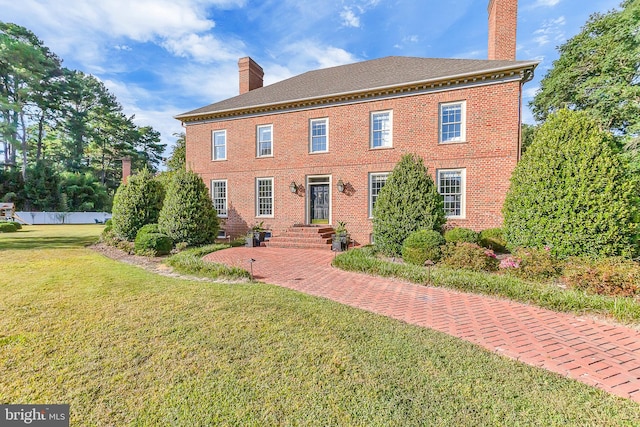 colonial home featuring a front lawn